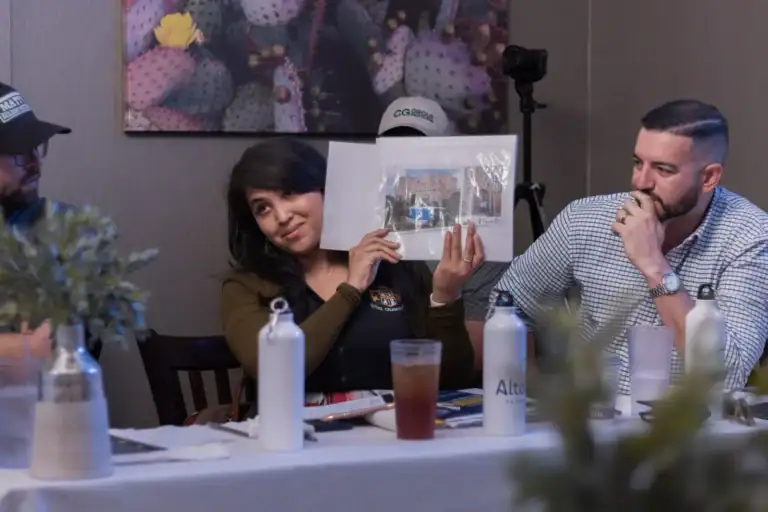 A participant shares a printed image during a table discussion.