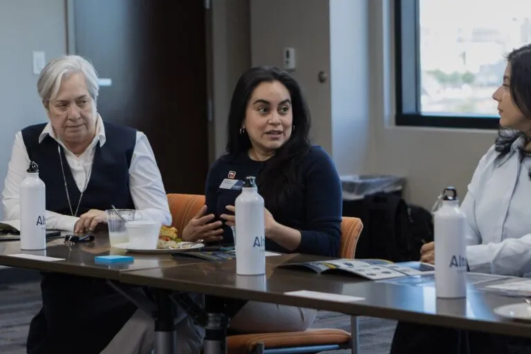 Participants exchange ideas at an education-sector meeting table.