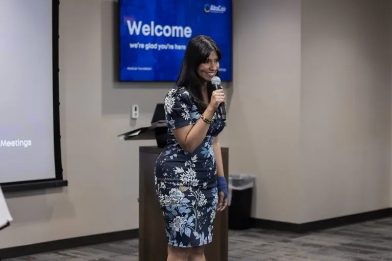 A speaker addresses the room with a handheld microphone.