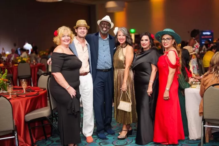 A group of guests gathers near the banquet seating.