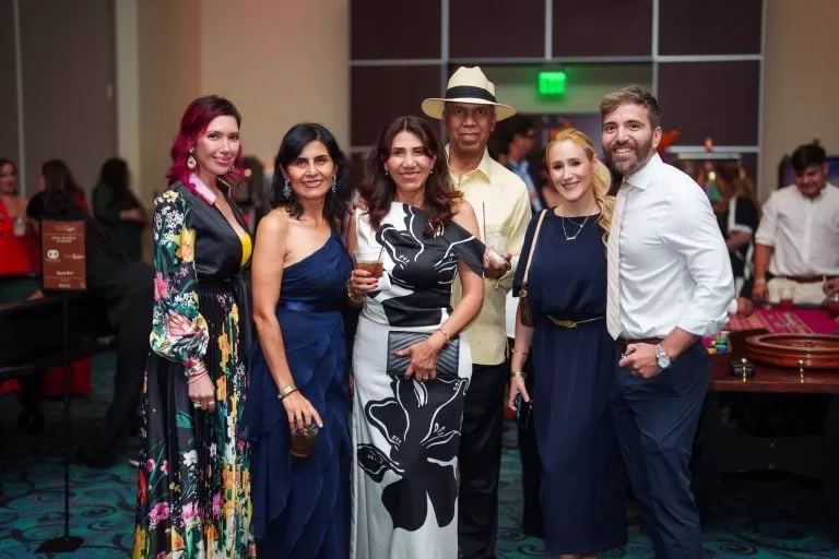 Guests pose together beside the event tables.