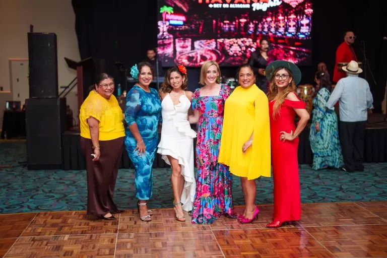 Guests stand together beneath the Havana Nights event sign.